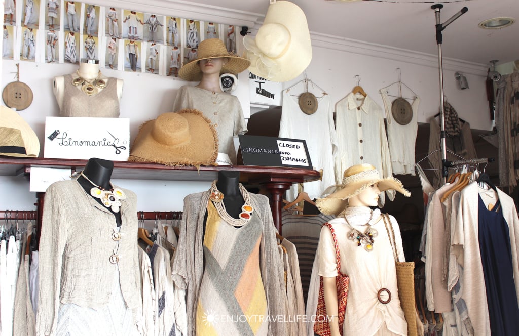 Linen clothing and straw hats on display at the Linomania boutique storefront