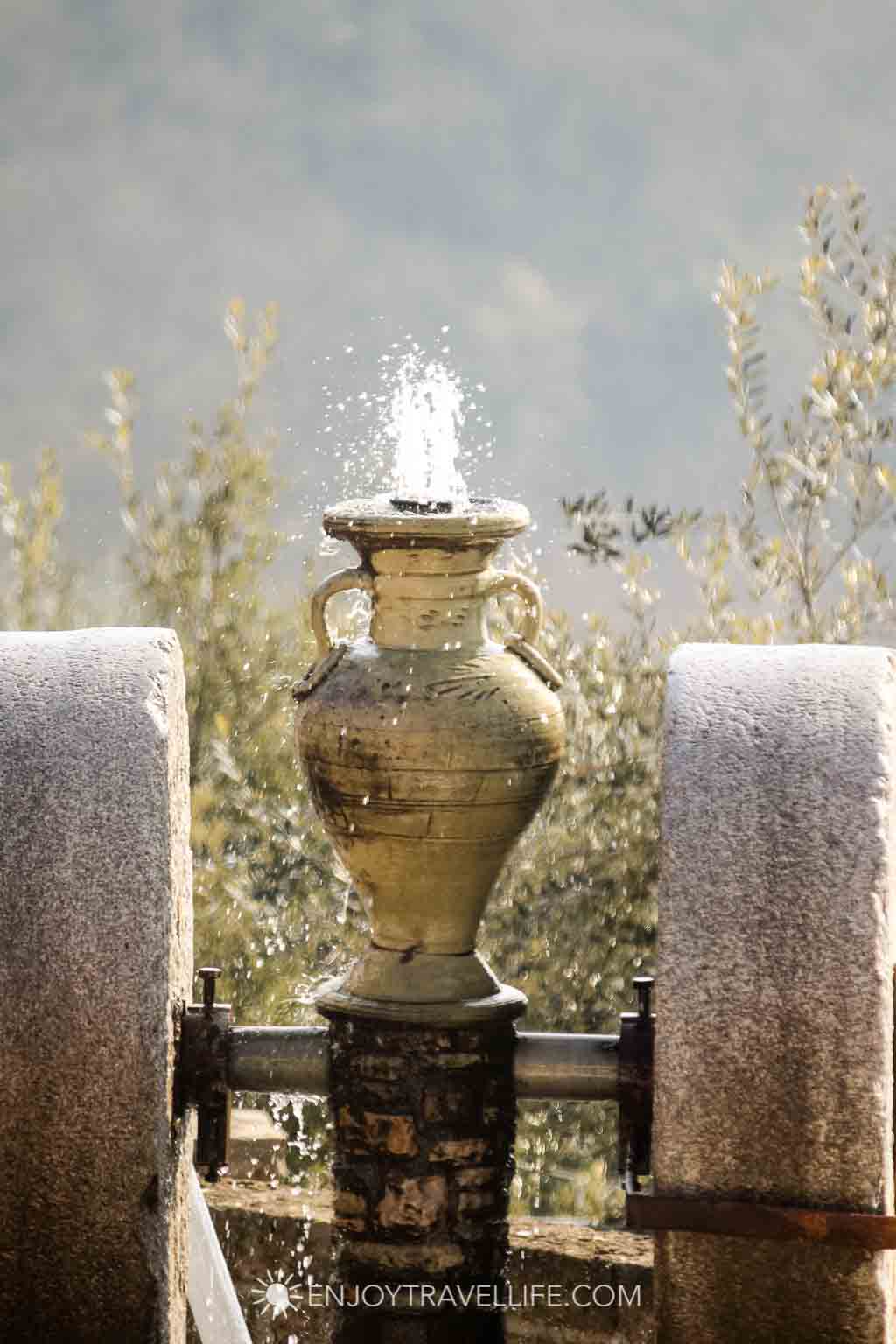 Ceramic urn fountain trickling water at an agriturismo farm stay in Avellino, Italy