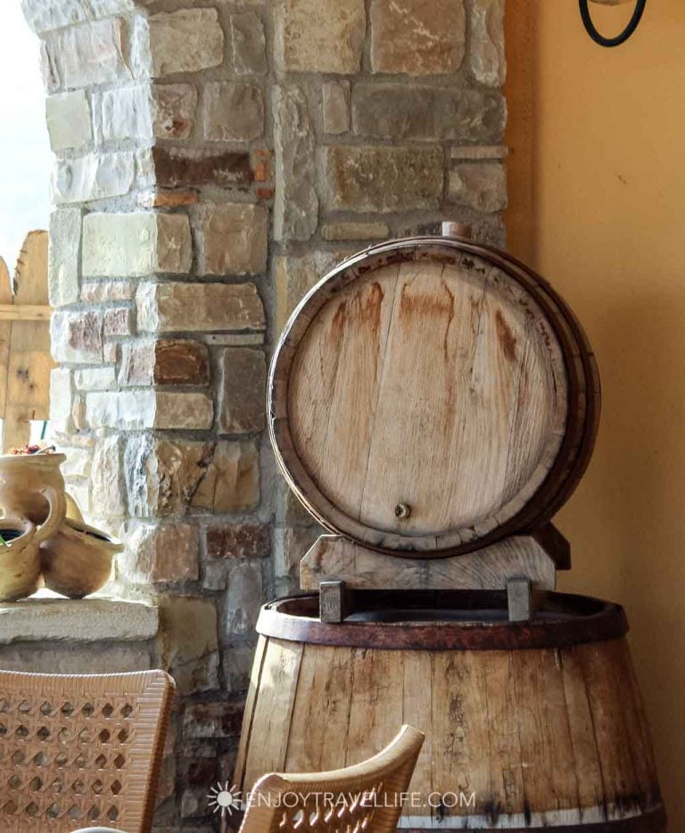 A wooden wine barrel with a tap against a stone wall at an agriturismo in Avellino, Italy