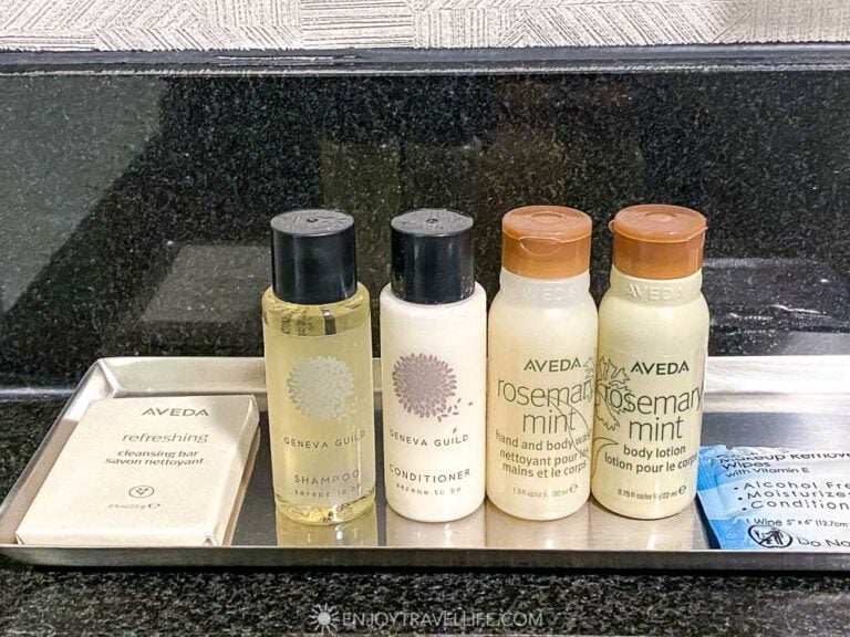 Travel toiletries sit arranged on a hotel bathroom counter.