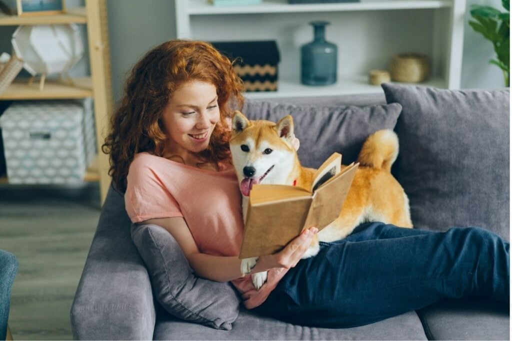 7 habitudes quotidiennes simples pour trouver l'équilibre dans la vie 2 Une femme lisant un livre avec le chien