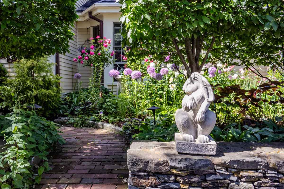 A brick garden path winding through layered plantings