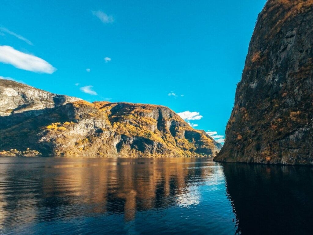 Flam shore excursions: Towering cliffs reflected in the calm water of the Naeroyfjord in Norway.