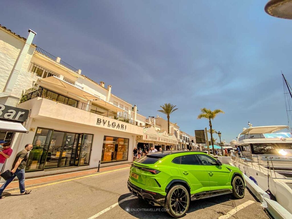 A green Lamborghini Urus parked outside the Bulgari store at Puerto Banús marina in Marbella, Spain