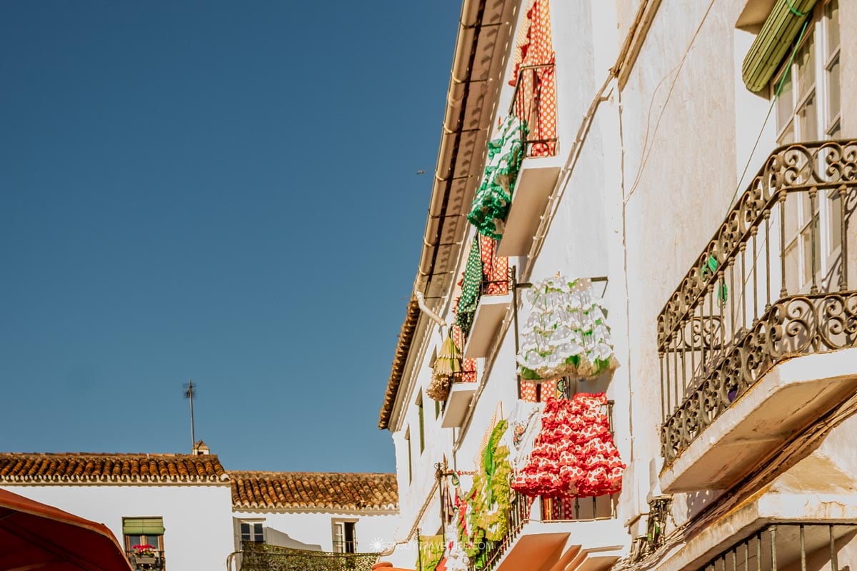 Marbella Old Town on the Costa del Sol with whitewashed buildings and colorful flamenco dresses on wrought iron balconies