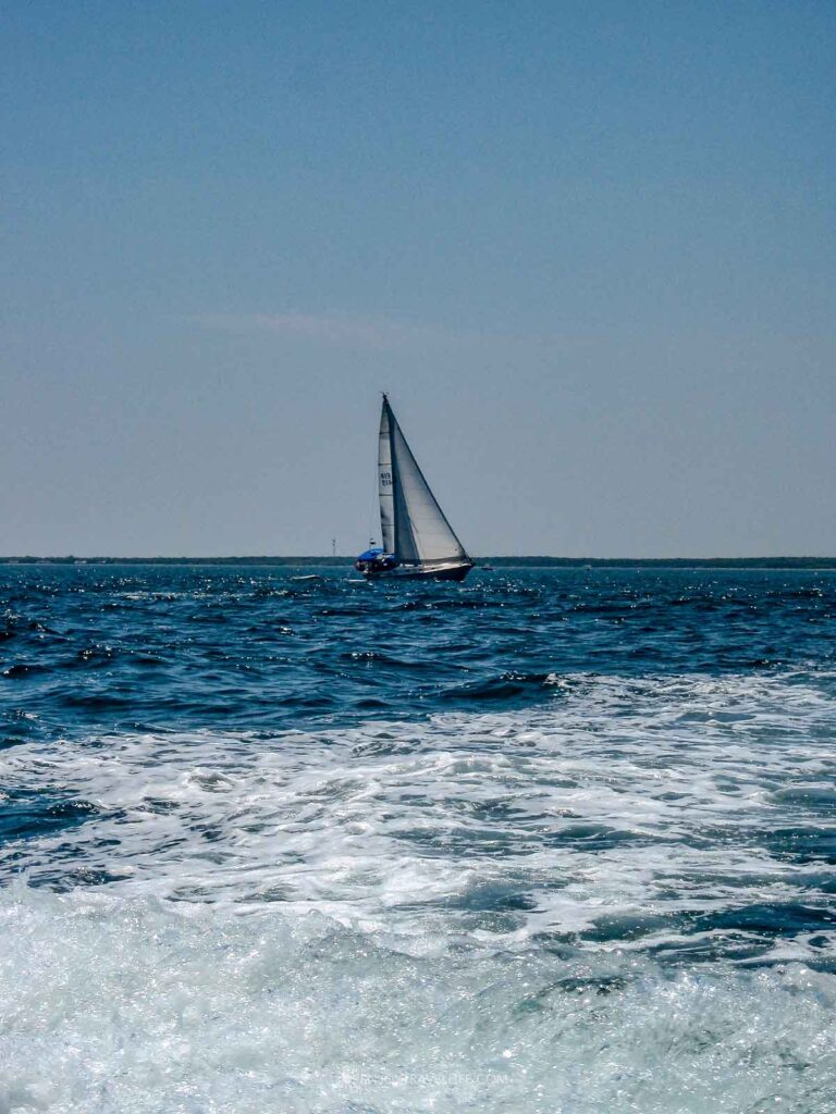 Sailboat in Vineyard Sound with ferry wake on a clear summer day