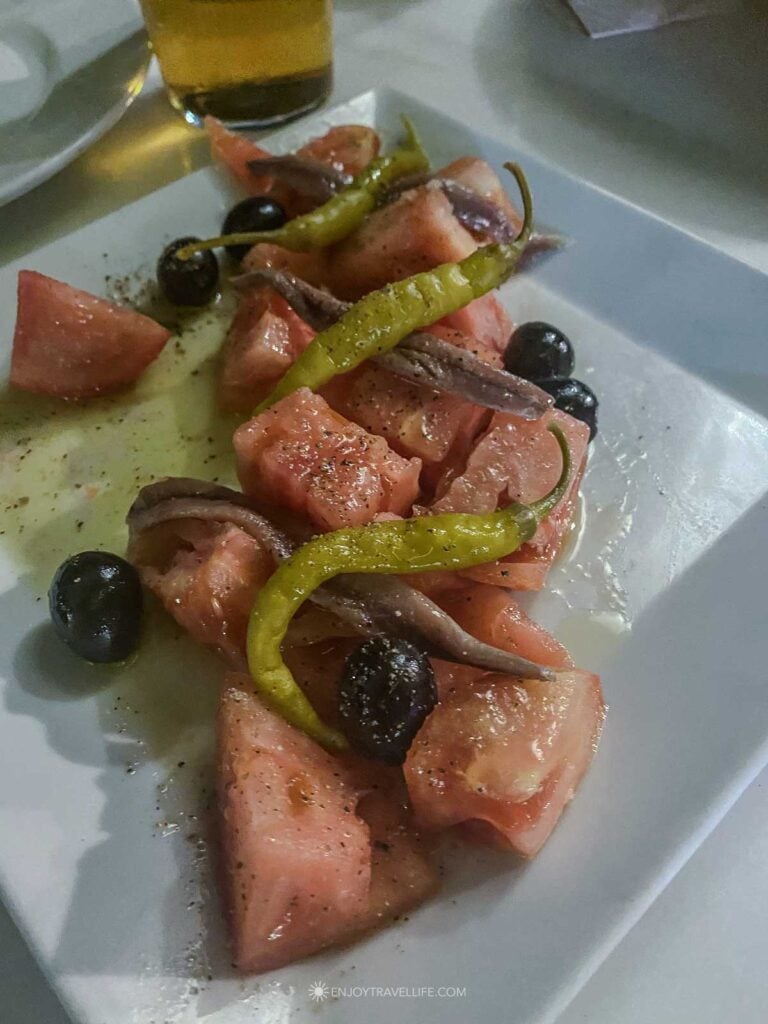 A tapa of tomato, anchovy, and olives at a traditional bar in Seville.