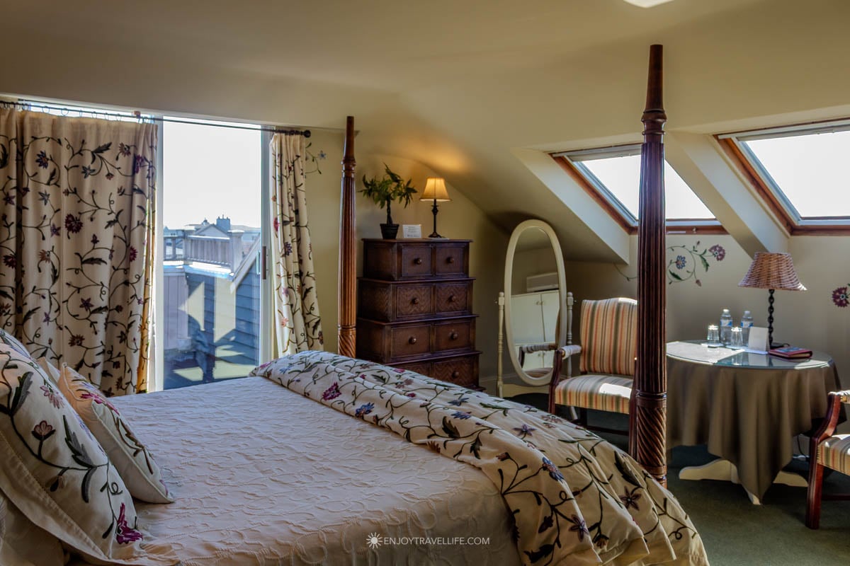 A four-poster bed anchors a cozy guest room at the Admiral Fitzroy Inn in Newport.