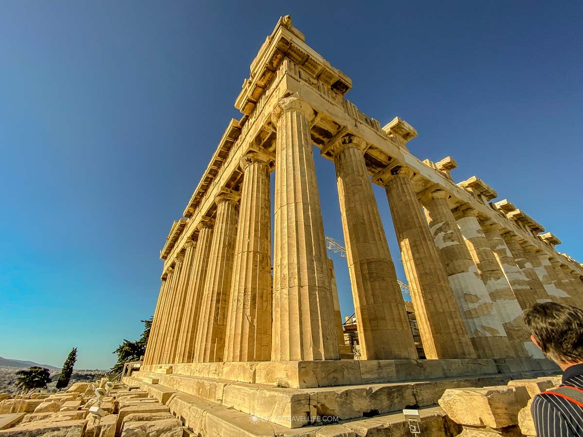 The columns of the Parthenon rise against a clear blue morning sky on the Acropolis in Athens, Greece.