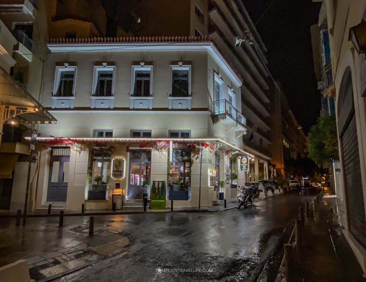 A quiet Athens street glistens under streetlights at night in central Athens, Greece.