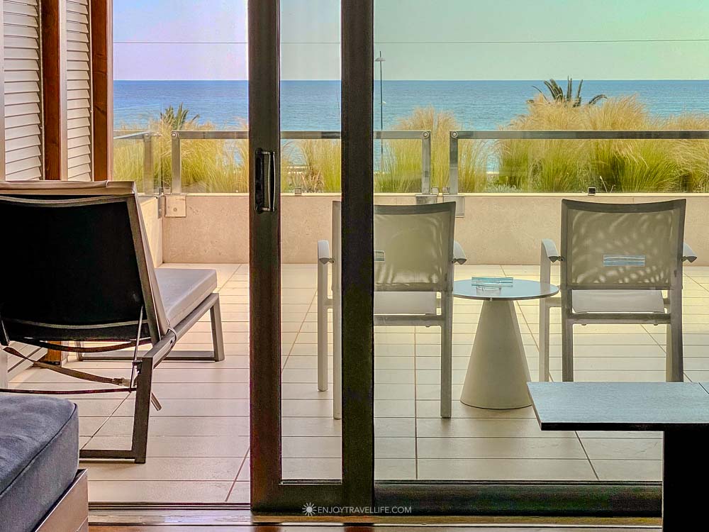 An ocean-view beachfront suite terrace with lounge chairs looking out to the sea