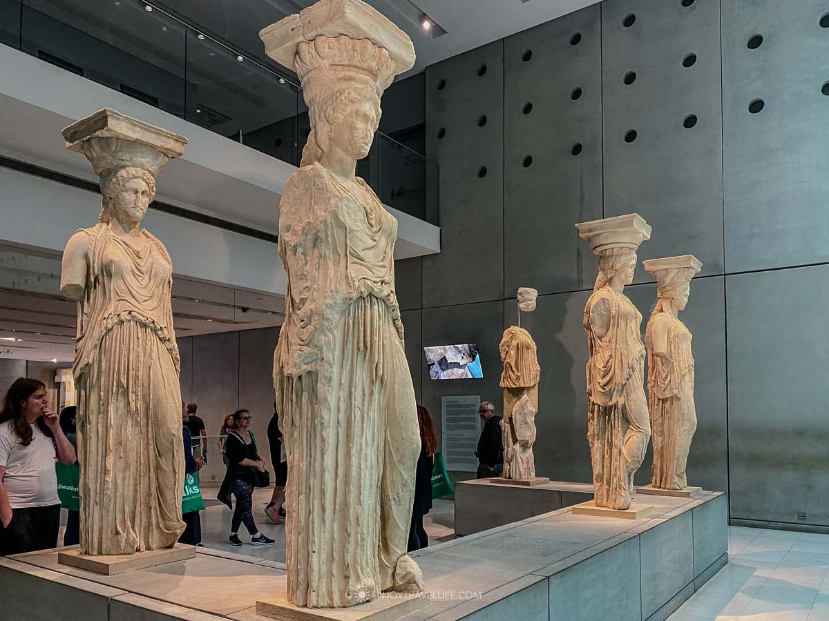 The original Caryatid statues from the Erechtheion stand on display inside the New Acropolis Museum in Athens.