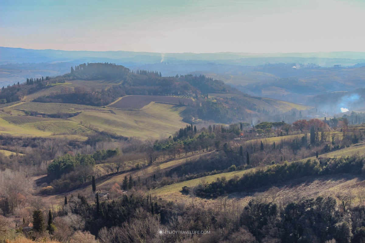 Golden Chianti hills with bare winter vineyards and scattered farmhouses in Tuscany