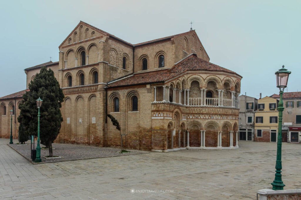 The brick facade of the Basilica dei Santi Maria e Donato, a 12th-century Byzantine church on Murano, rises under a gray winter sky.