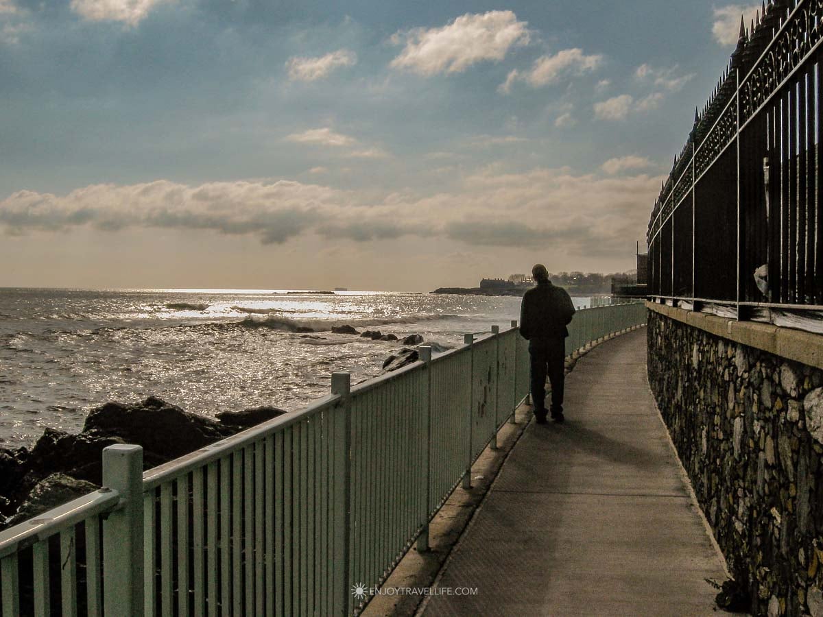 The Cliff Walk traces the shoreline past mansion lawns and open ocean in Newport.