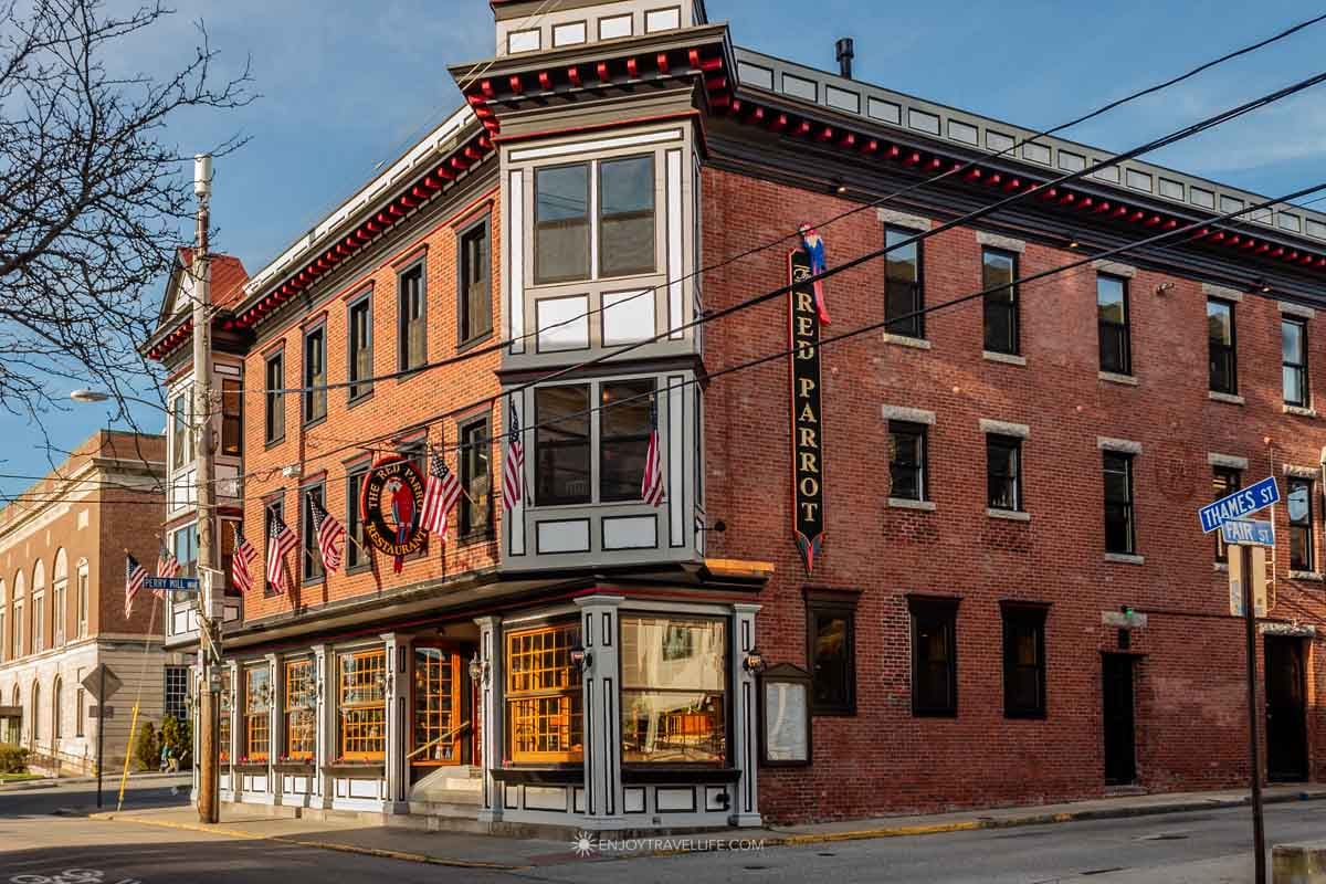Shoppers stroll past colorful storefronts along Thames Street in downtown Newport.