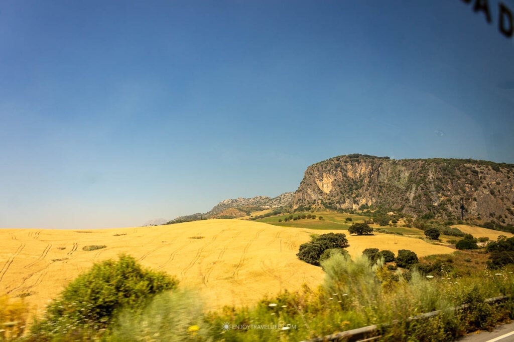 Golden Andalusian countryside and a limestone sierra on the drive to Seville.