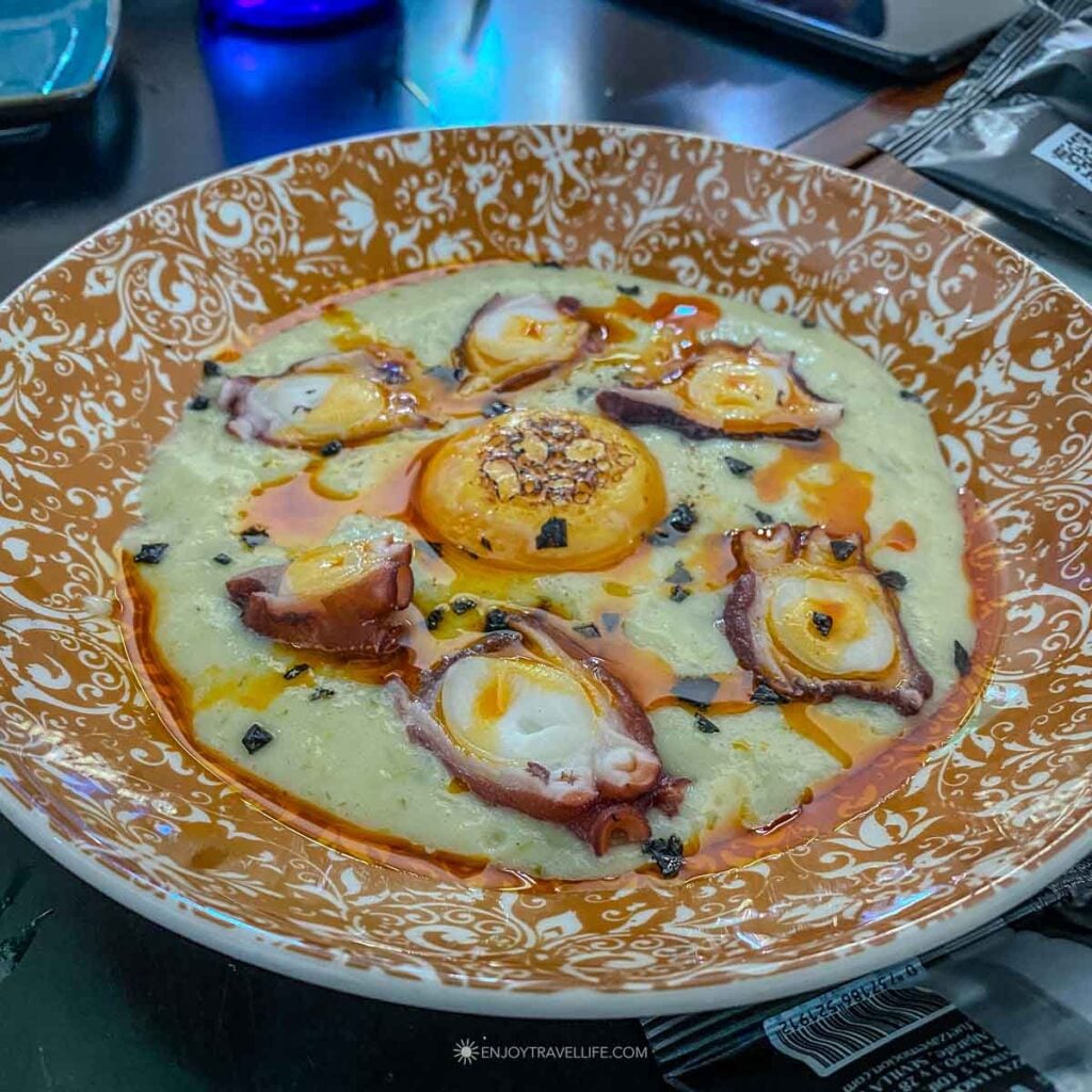 A dish of octopus over potato in a green sauce at Casa Montalván in Seville.
