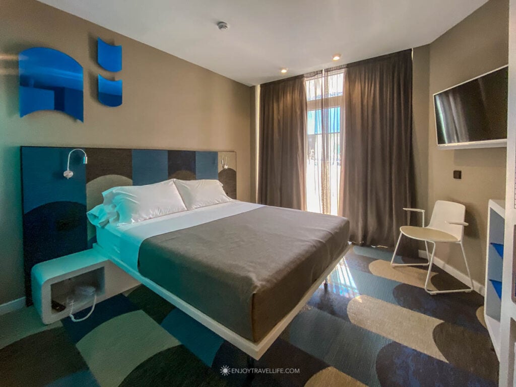 A modern guest room with teal accents at the Hotel Macià Sevilla Kubb in Seville.