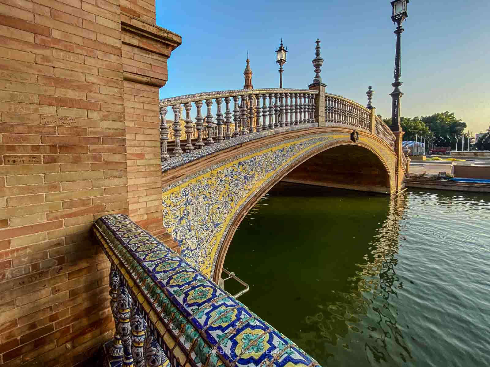 A tiled bridge arches over the canal at the Plaza de España at golden hour, a highlight of 2 days in Seville.