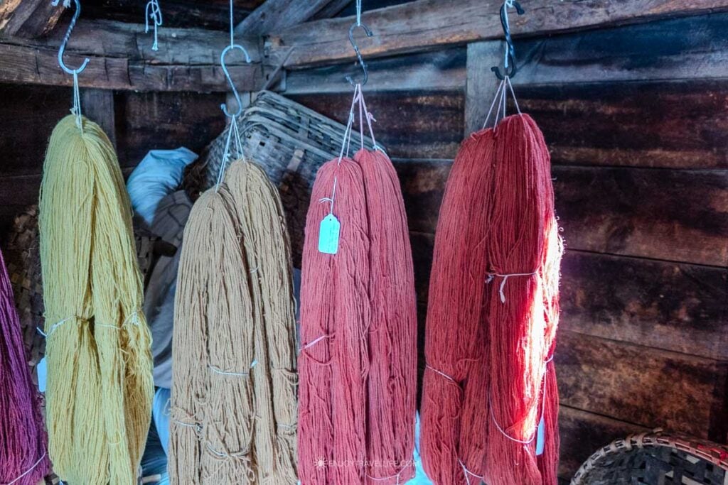 Skeins of naturally dyed wool hang from the rafters of the wool house.
