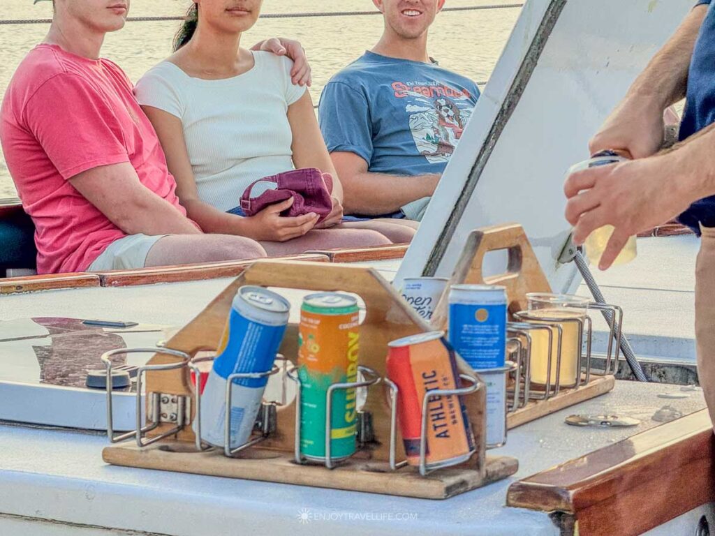 A wooden caddy of drinks sits on a bench aboard the schooner during an evening sail in Boston Harbor.
