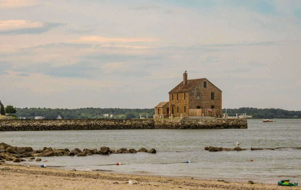 A weathered shingled house overlooks the stone breakwater at Gray's Beach in Kingston, just north of Plymouth.