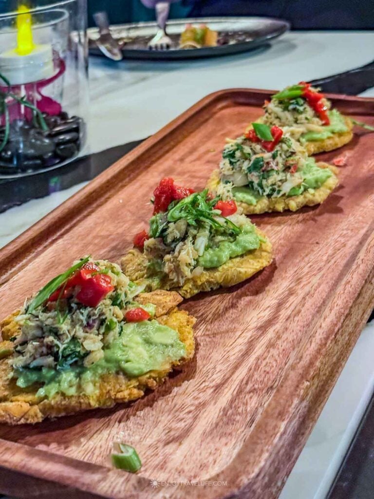 Tostones topped with guacamole and salsa on a wooden board at Havana Nights in Worcester.