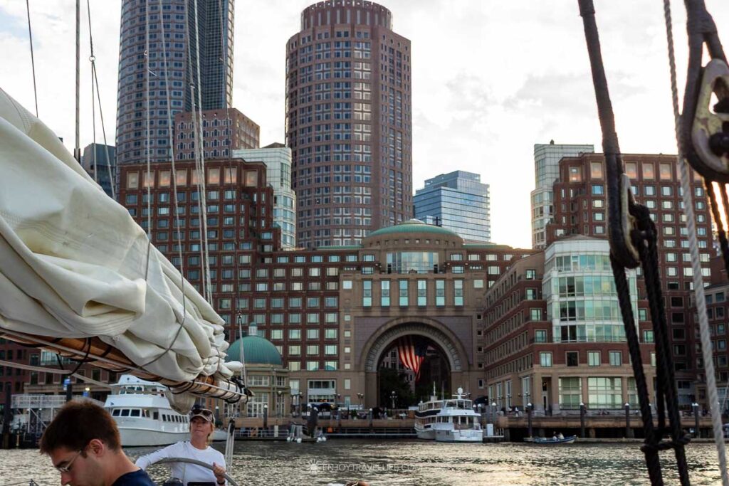 The Boston skyline and the Rowes Wharf arch seen from the schooner's deck as she pulls away from the dock.