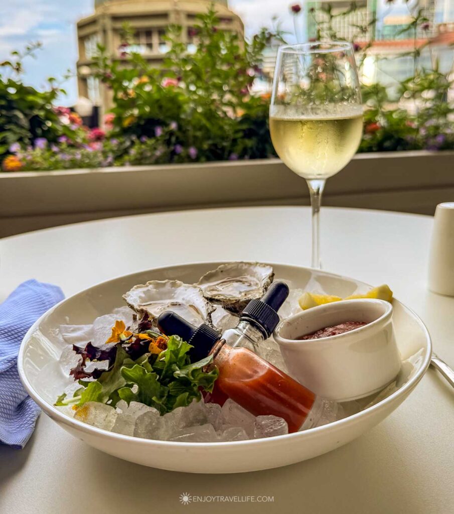 Oysters on ice with a glass of white wine on the terrace at Rowes Wharf Sea Grille in Boston.