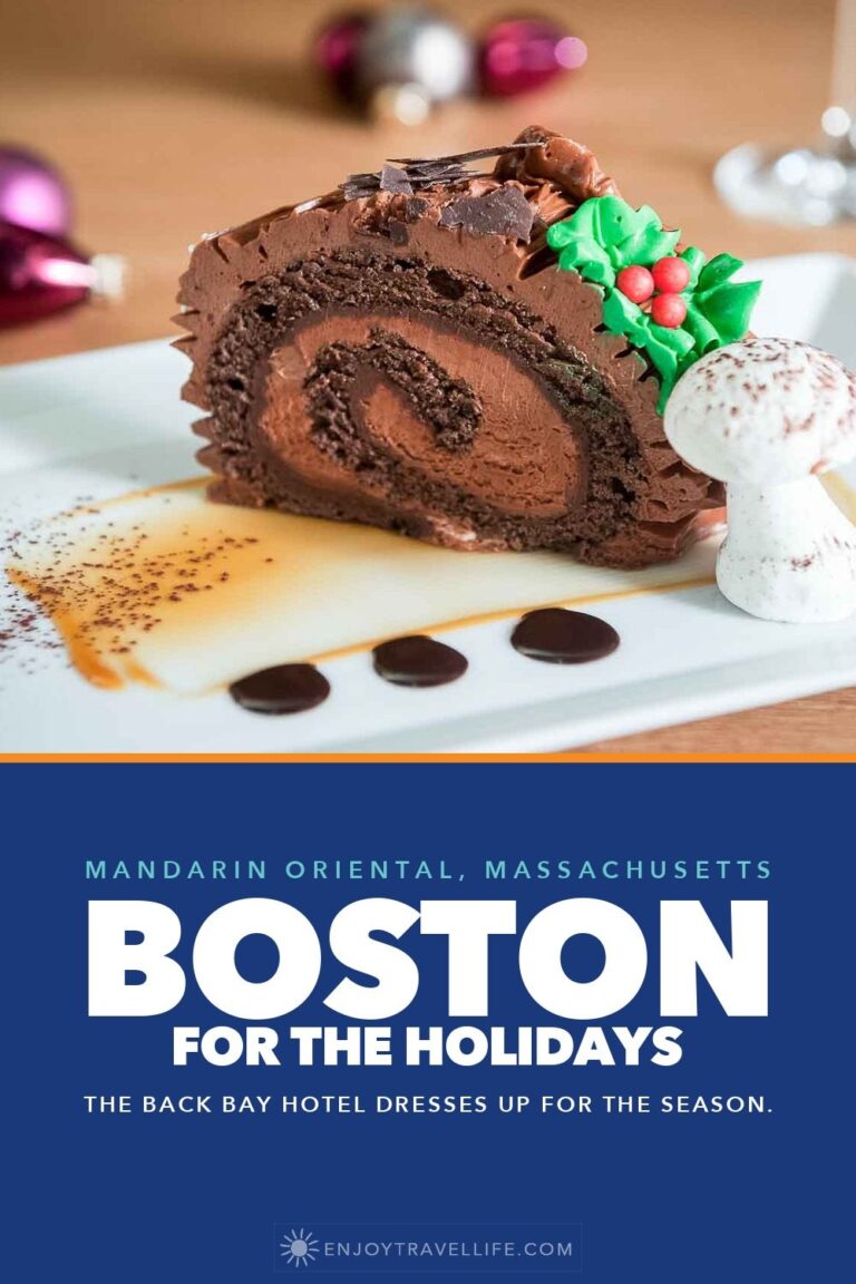 A slice of chocolate bûche de Noël with holly and a meringue mushroom on a white plate at the Mandarin Oriental, Boston.