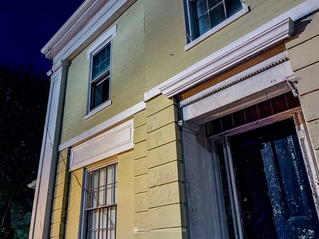 The Captain Taylor House, a yellow Greek Revival house on North Street in Plymouth, lit at night.