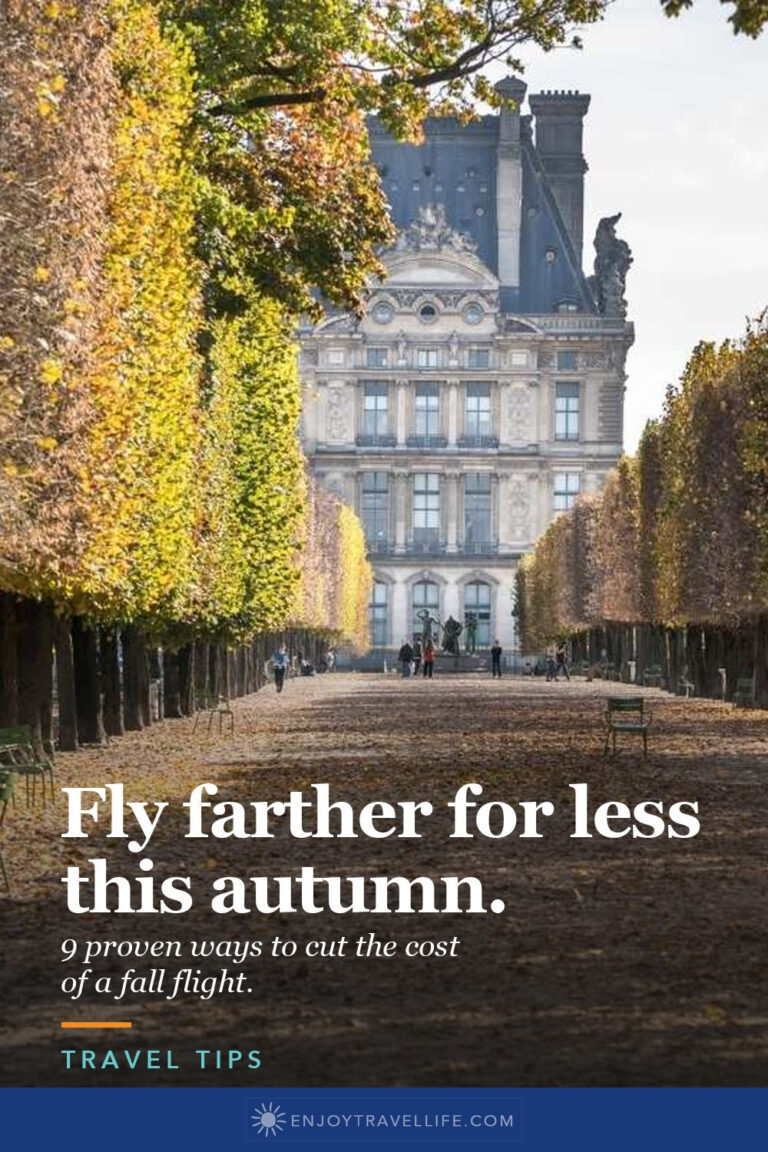 A tree-lined avenue of fall leaves leading to the Louvre in Paris.