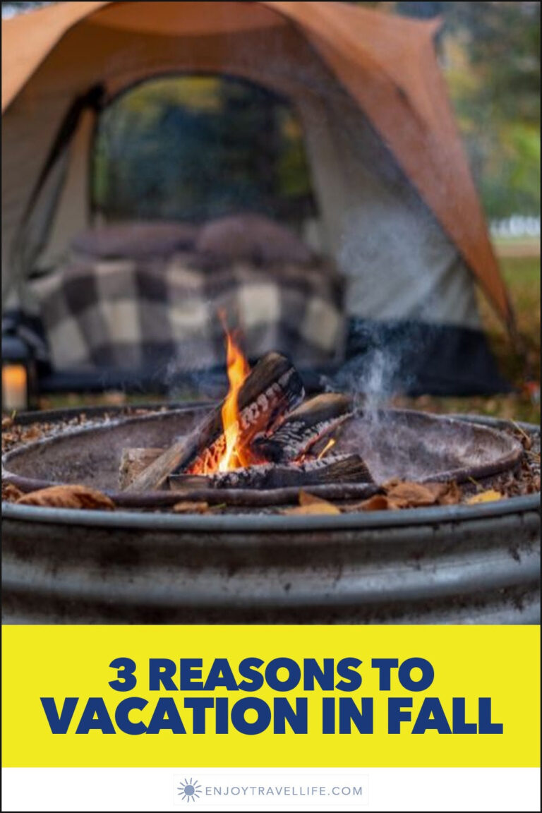 A campfire in a metal ring beside an orange tent.