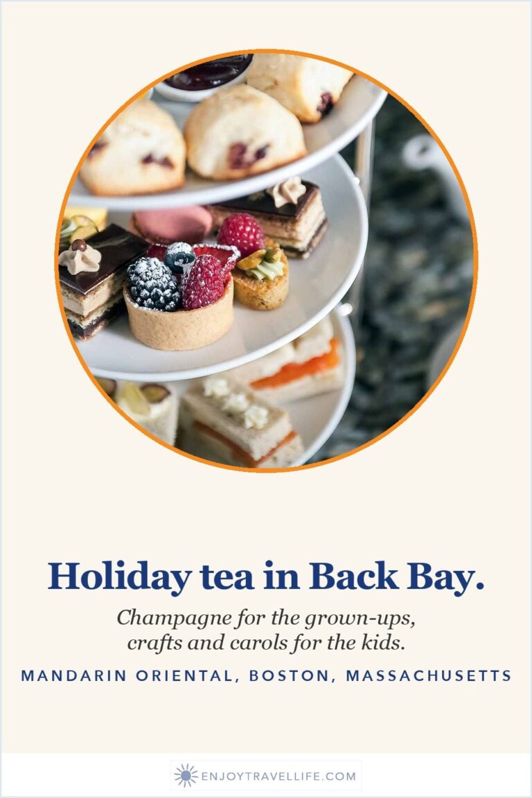 A three-tier stand of scones, pastries and finger sandwiches beside a teacup at the Mandarin Oriental, Boston.