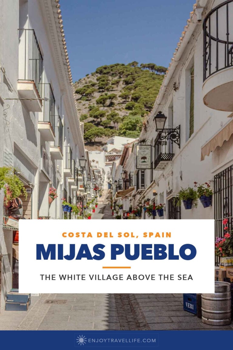 A narrow whitewashed street with flower pots in Mijas Pueblo on Spain's Costa del Sol.