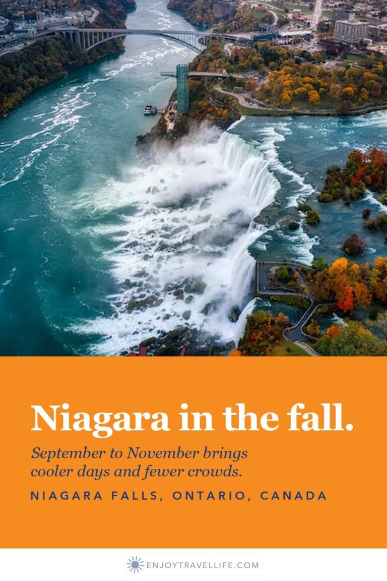 Aerial view of Niagara Falls with autumn foliage along the river and the Rainbow Bridge beyond.