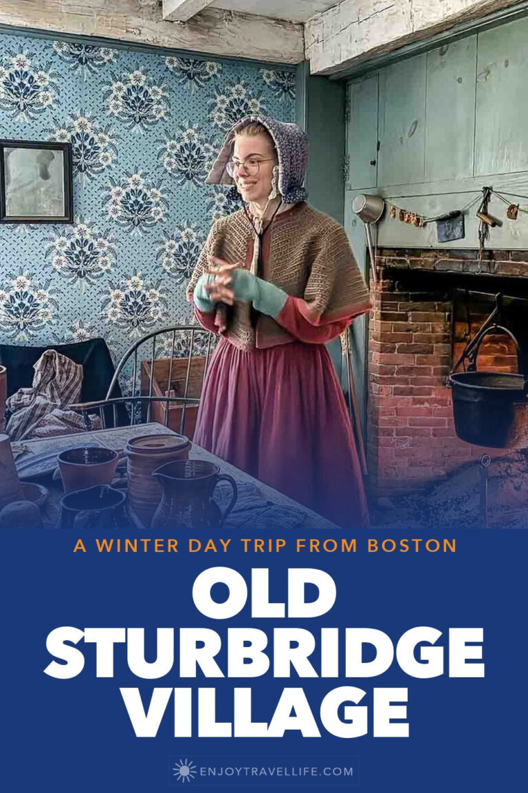 A costumed interpreter stands by the hearth in a period kitchen at Old Sturbridge Village, Massachusetts.