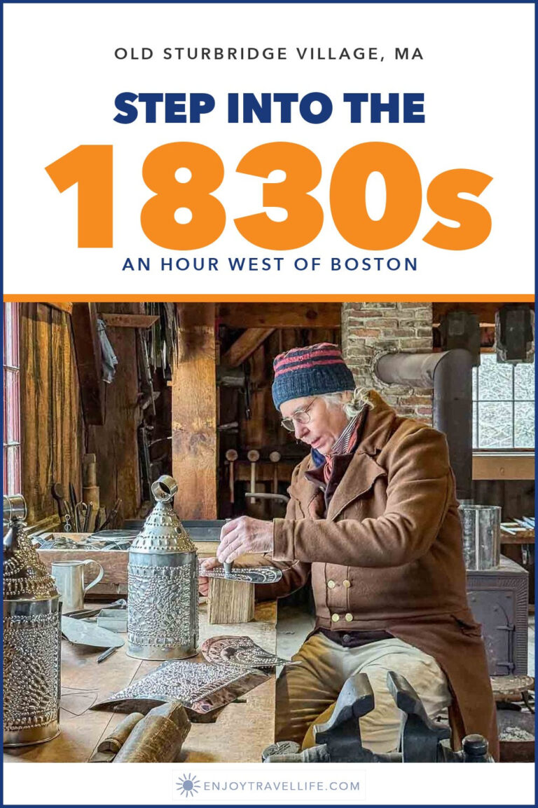 A tinsmith in period dress works on a lantern at his bench at Old Sturbridge Village, Massachusetts.