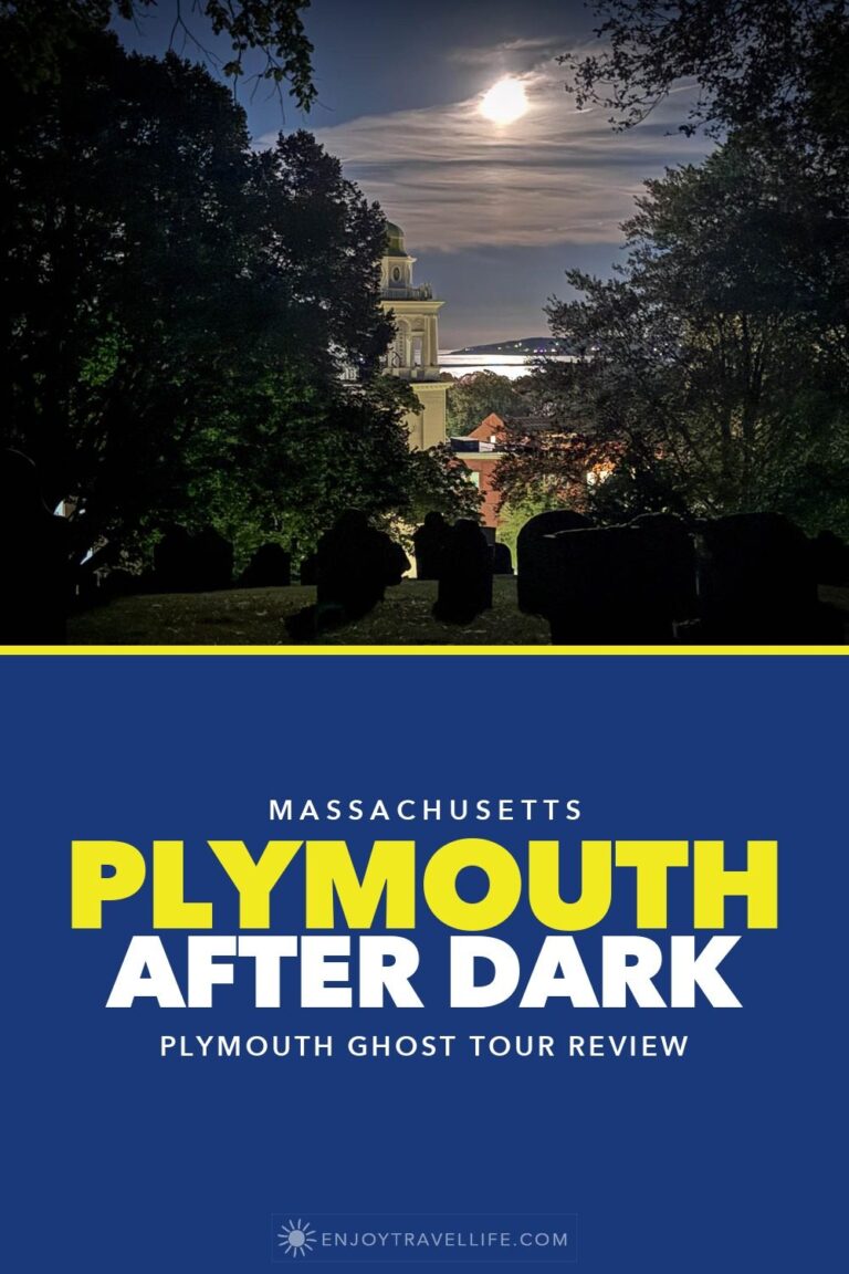 The moon over Plymouth Harbor seen from Burial Hill at night, with headstones in the foreground.