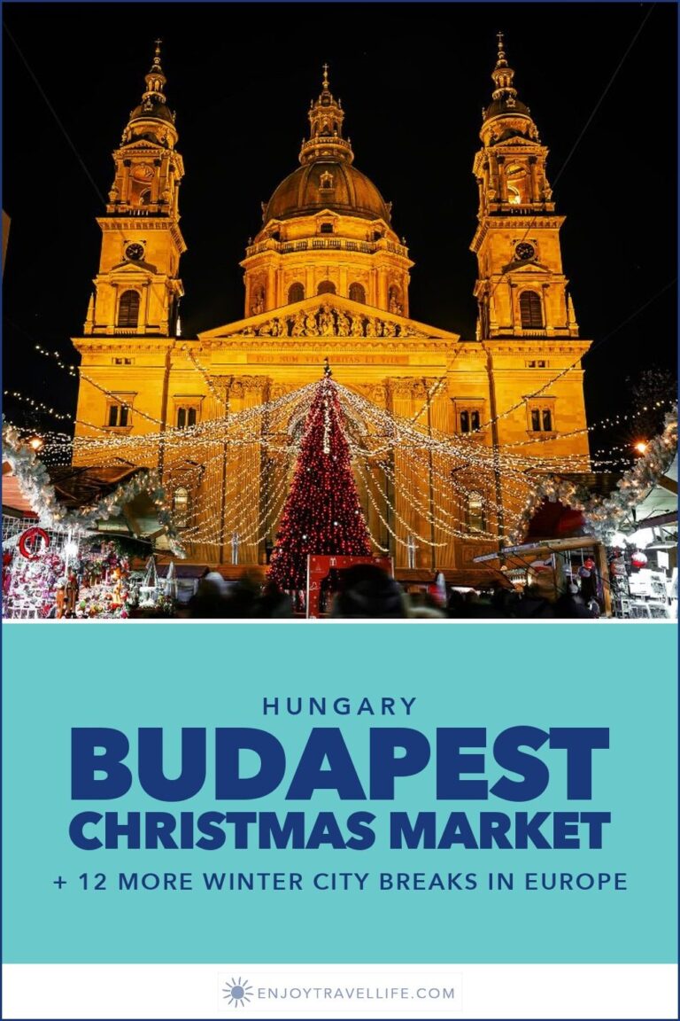 St. Stephen's Basilica lit up behind a Christmas tree at night in Budapest, Hungary.