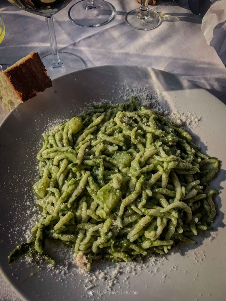 A plate of chestnut flour trofie with pesto in the Cinque Terre, Italy, is one of the authentic food experiences worth researching before a trip.