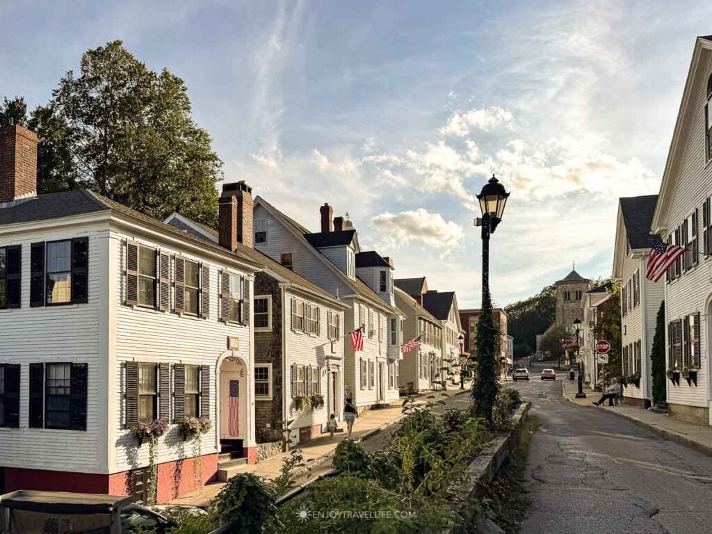 White clapboard houses and a black lamppost line Leyden Street in Plymouth, Massachusetts.