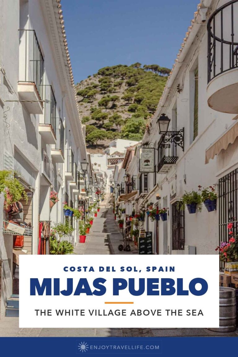 A narrow whitewashed street with flower pots in Mijas Pueblo on Spain's Costa del Sol.