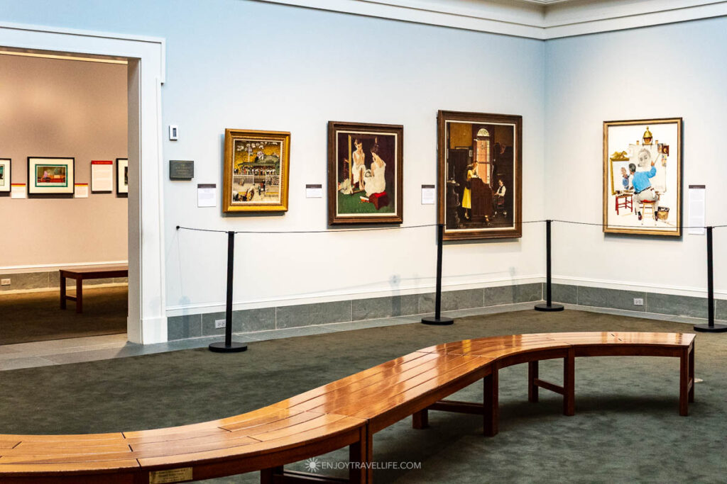 Paintings and a curved bench in a gallery at the Norman Rockwell Museum in Stockbridge.