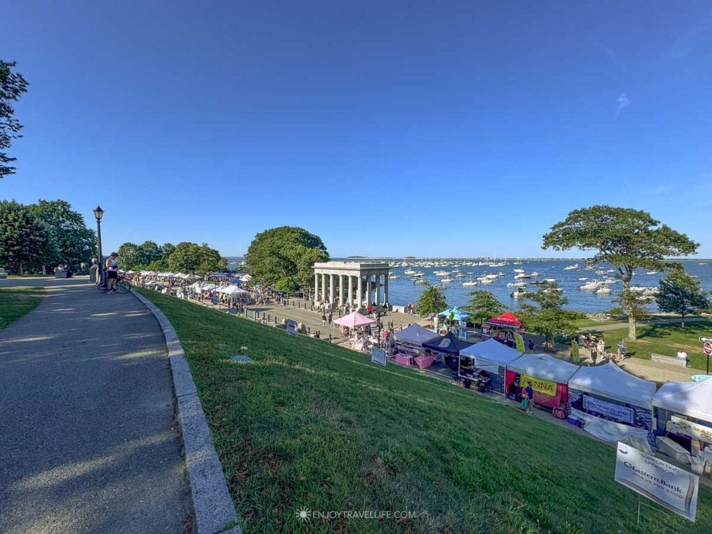 Vendor tents for the Plymouth Waterfront Festival line the harbor below the Plymouth Rock portico.